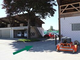 Zwischen beiden Gebäuden links abbiegen und 50 m weiter geradeaus laufen.